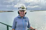 Smiling woman in front of breakwater