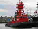 Red and black tugboat alongside